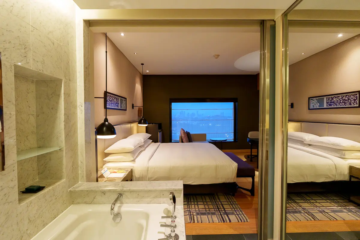 ヒルトンクアラルンプールのデラックスルームのバスルームから見たベッドルーム